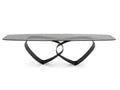 A modern rectangular coffee table with a dark textured stone top and a sculptural black metal base featuring interlocking curved legs, shown against a plain white background.