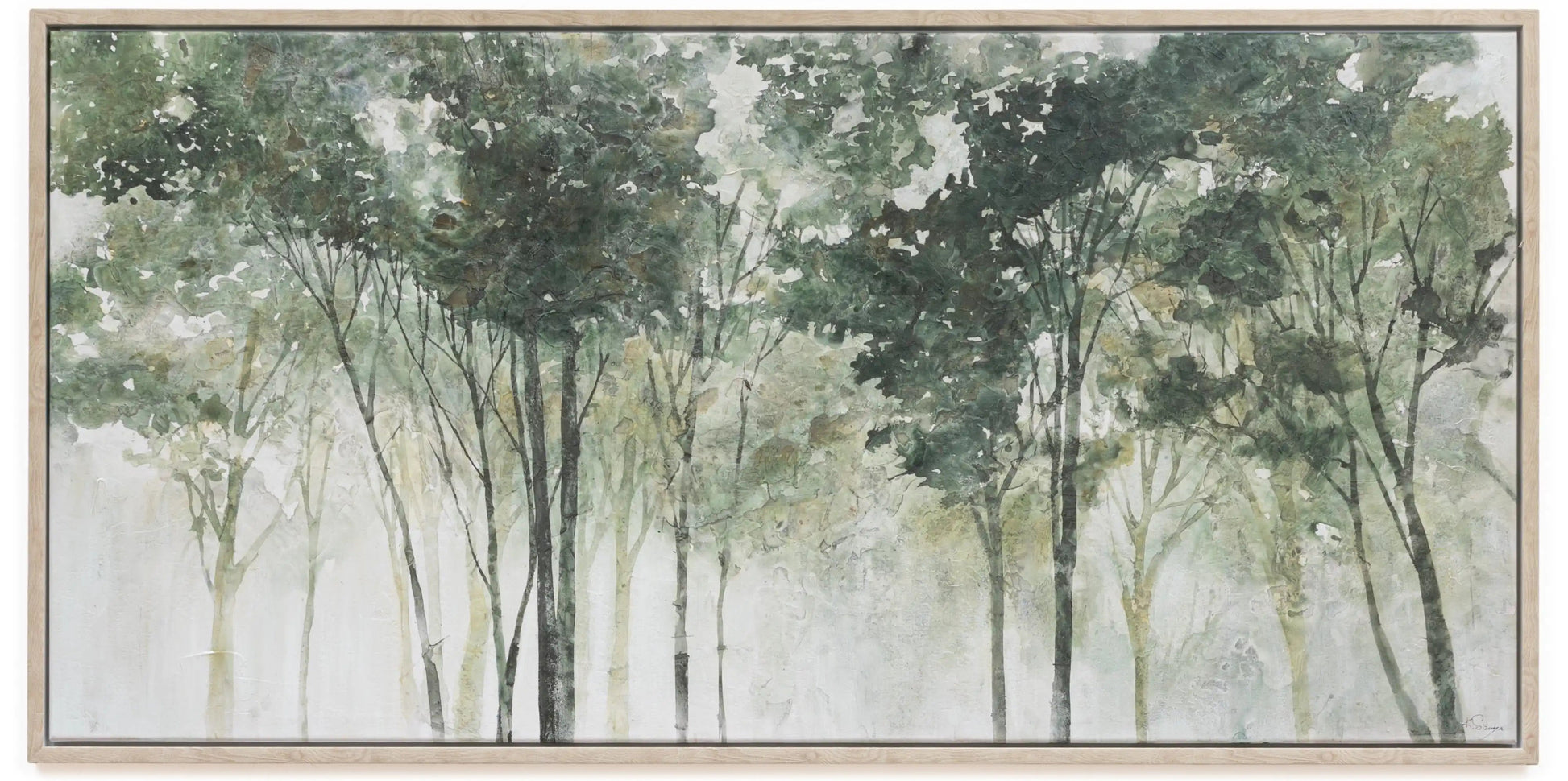A framed horizontal canvas print depicting a misty forest with tall trees in soft shades of green, gray, and white, set in a light natural wood frame.