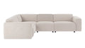 A modern sectional sofa in a light beige fabric, featuring a left-facing chaise lounge and a three-seater section, shown against a plain white background.