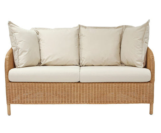 Wicker outdoor sofa with beige cushions on a white background