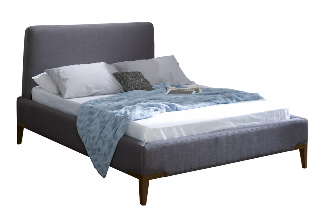 Gray upholstered bed with white mattress and blue blanket on a white background