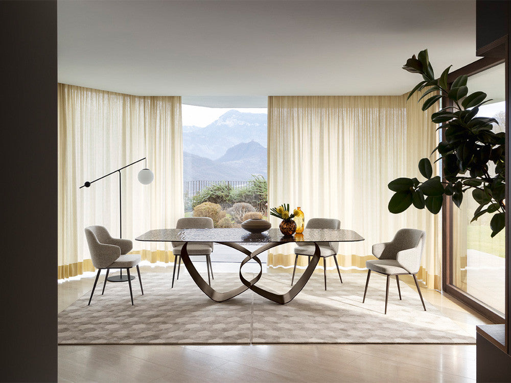 A modern rectangular coffee table with a dark textured stone top and a sculptural black metal base featuring interlocking curved legs, shown against a plain white background.