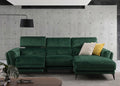 Green sectional sofa in a modern living room with concrete walls.