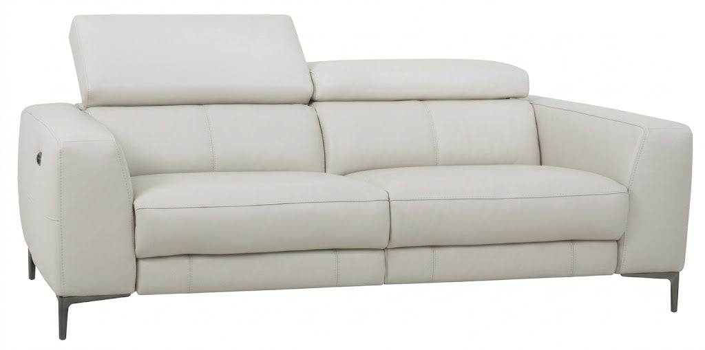A modern two-seater sofa upholstered in light cream or off-white leather, shown from a three-quarter angle against a plain white background.