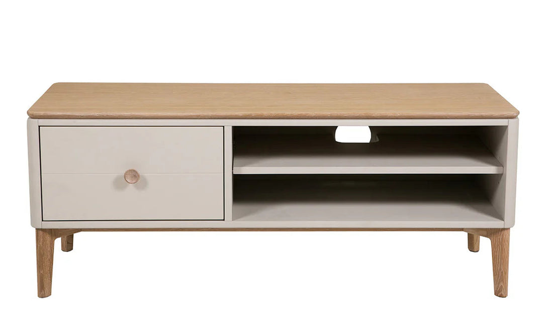 A modern low TV stand or coffee table with a light natural wood top and legs, and a white cabinet drawer on the left with a round wooden knob. The right side features open shelving with a center cutout.