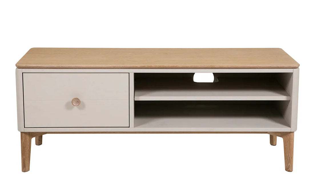 A modern low TV stand or coffee table with a light natural wood top and legs, and a white cabinet drawer on the left with a round wooden knob. The right side features open shelving with a center cutout.