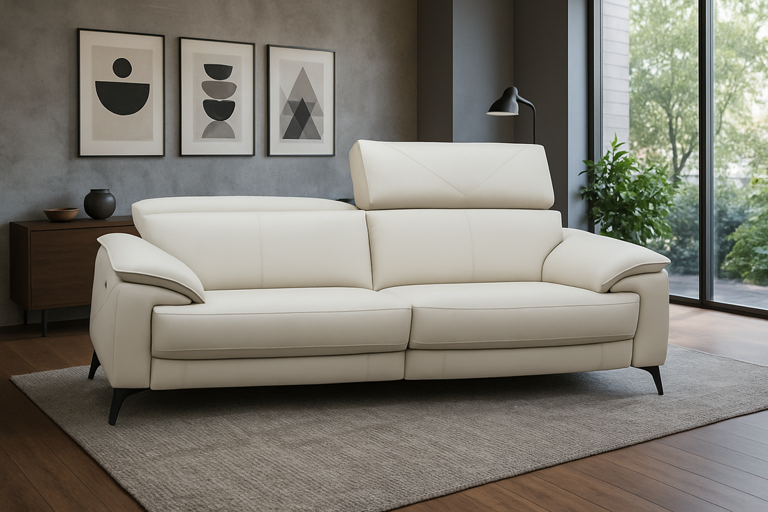 Beige sofa in a living room with framed art on the wall and a window in the background.
