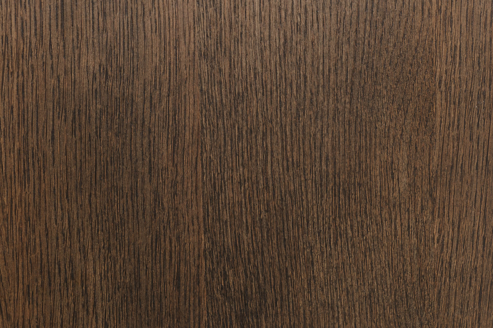 Close-up of a wooden surface with a dark brown color and visible grain pattern.